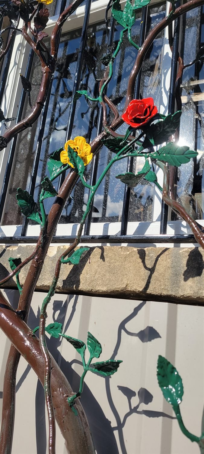 Painted rose and leaf detail on bespoke steel tree security bars