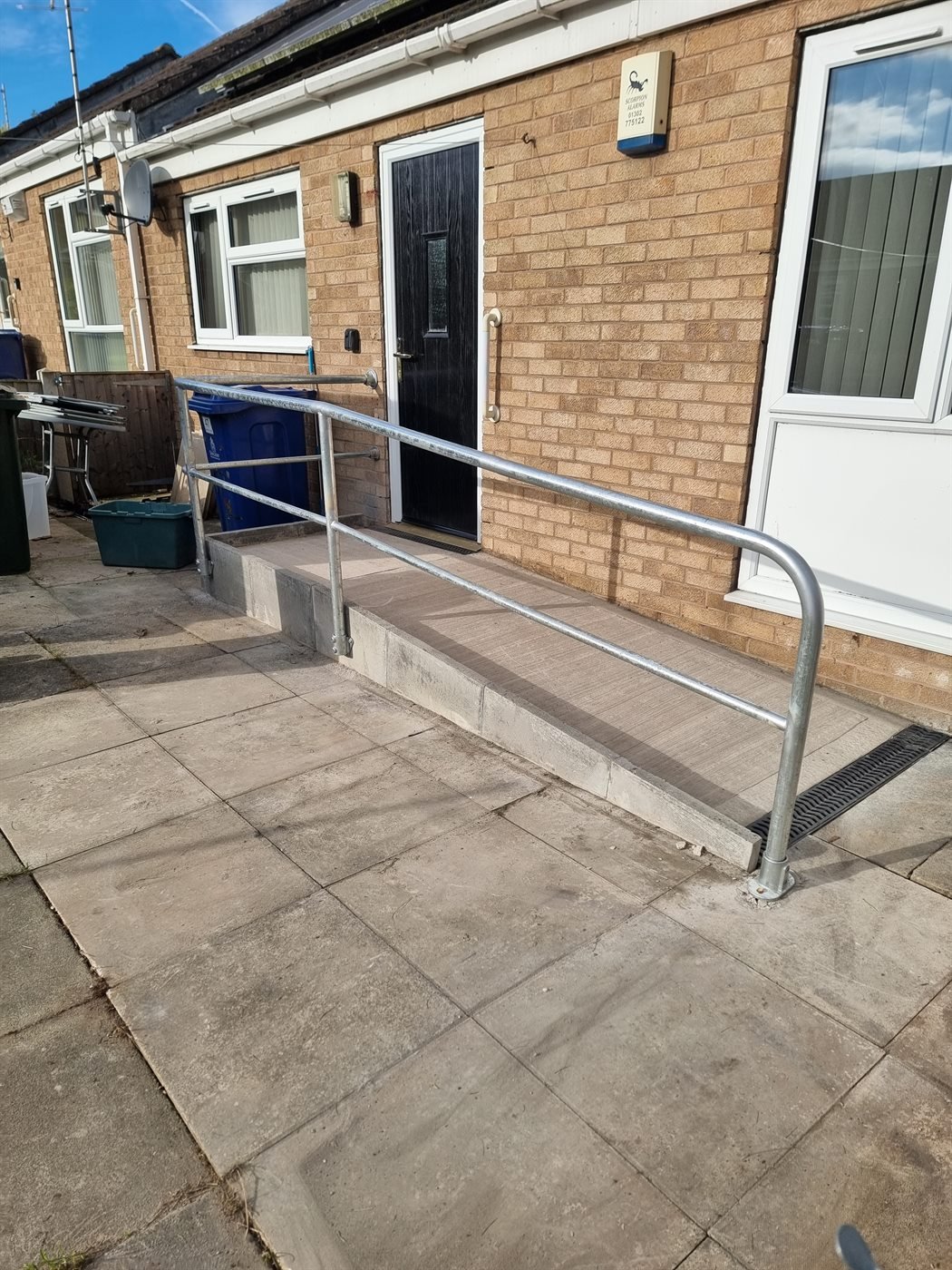 Steel handrail fitted to a paved ramp