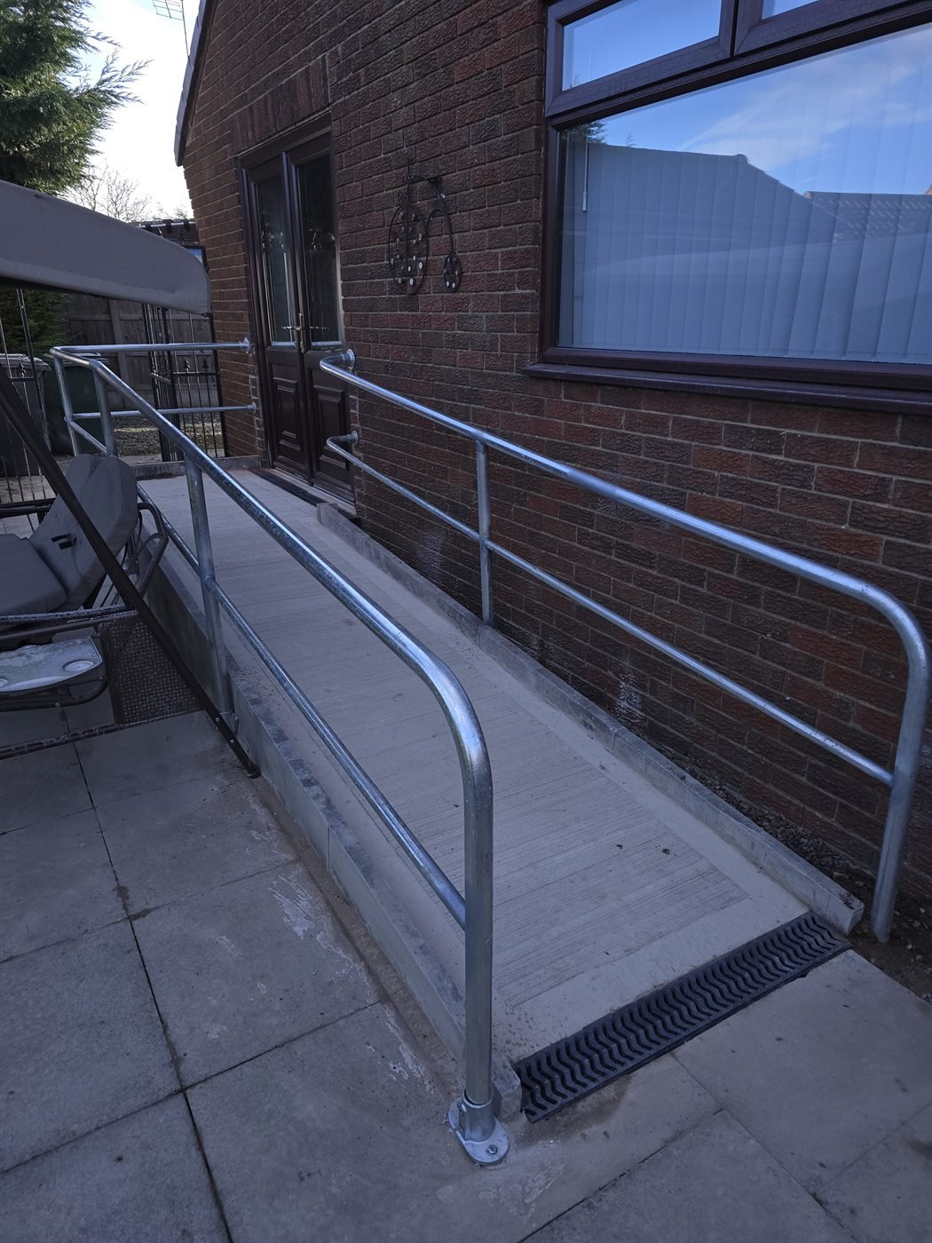 Steel handrail fitted beside a brick doorway