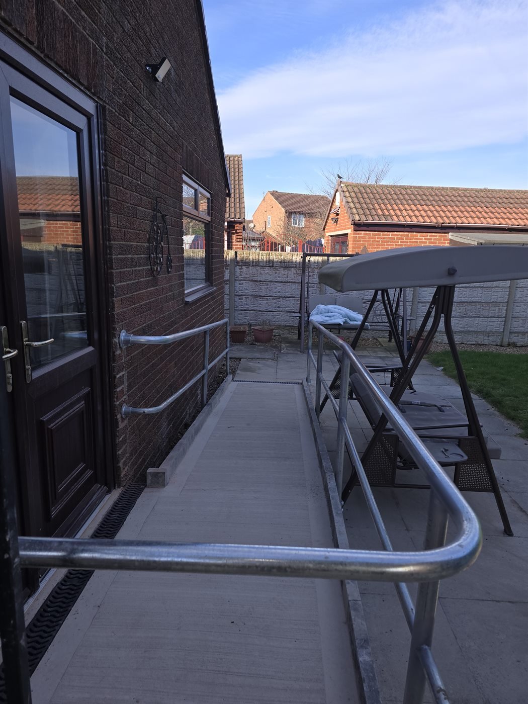 Metal handrail fitted beside outdoor paving
